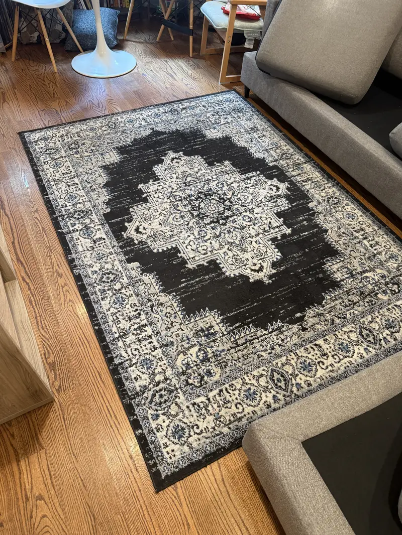 The same black and ivory medallion rug after on-site cleaning, with clean, even pile